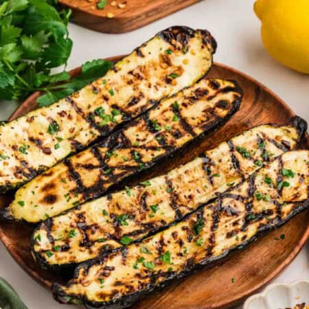 Grilled zucchini on a wooden plate.