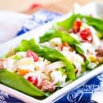 Lettuce cups filled with lunchmeat, veggies, and dressing on a platter with text overlay that says "Ham and Turkey Lettuce Wrap Sandwich".