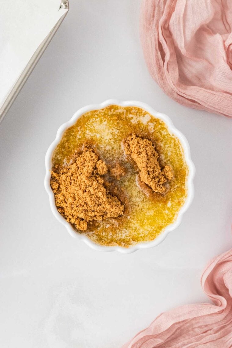 Combining melted butter and gluten free graham cracker crumbs.