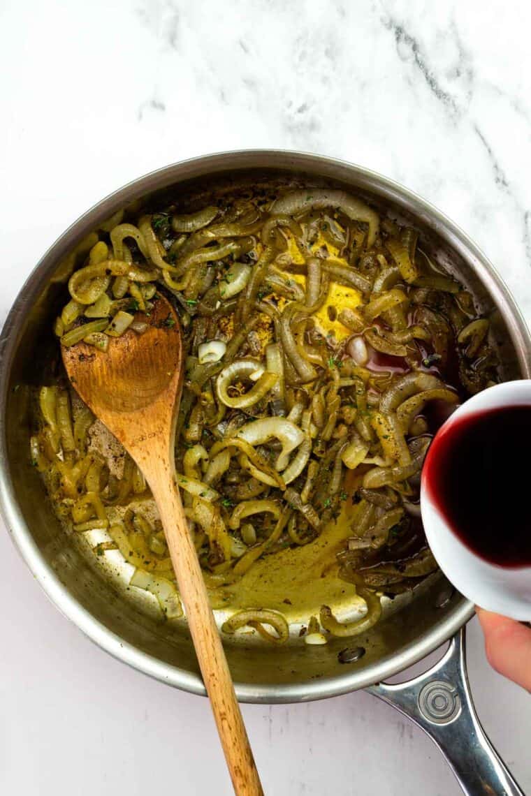 Adding wine and broth to caramelizing onions.