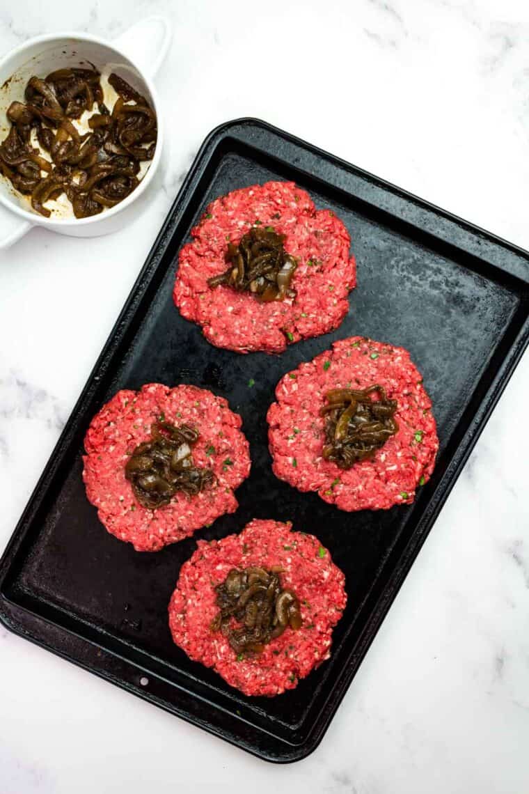 Stuffing burger patties with caramelized onions.