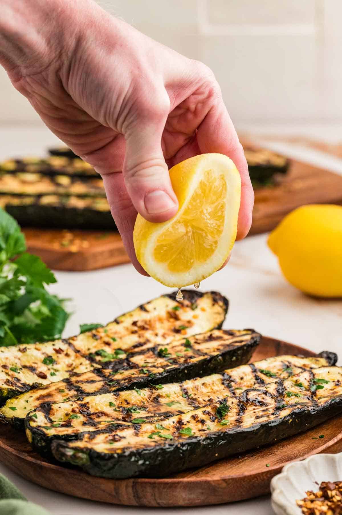Squeezing lemon over grilled zucchini.