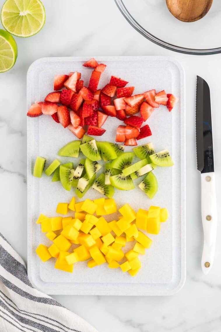 Cutting up mangos, kiwi, and strawberries.