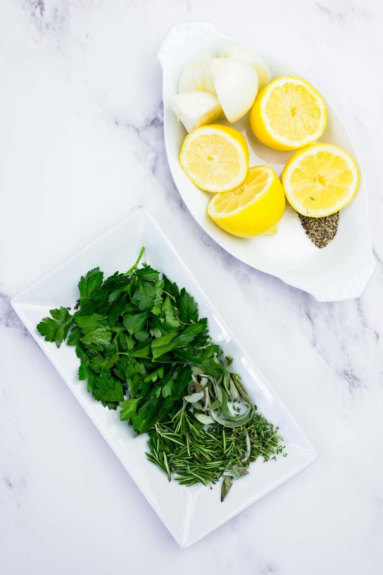 Plates with lemon halves and herbs.