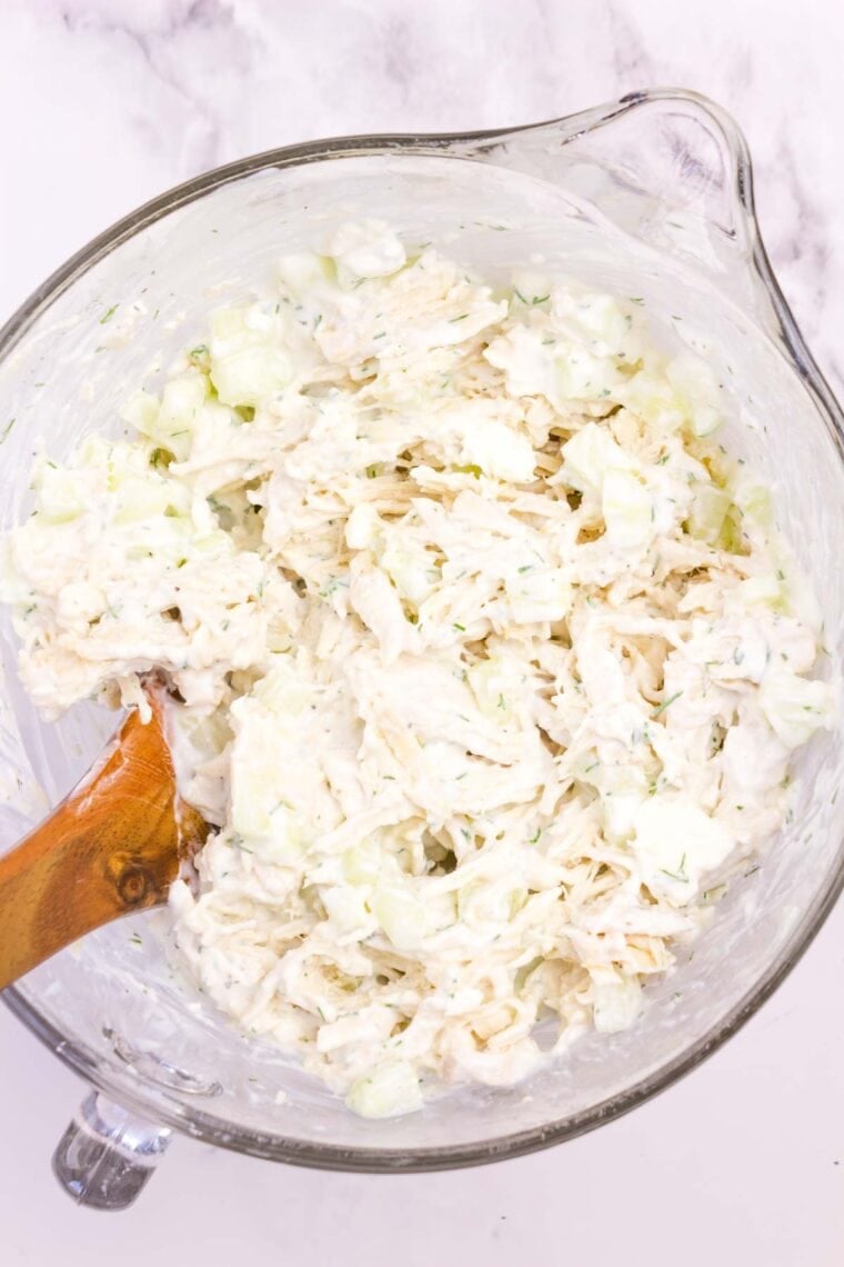 This Greek-ish tzatziki chicken salad combines juicy chicken, crunchy cucumber, and tangy Greek yogurt dressing with lemon, dill, and garlic. Tossing shredded chicken, feta, and cucumber with Greek yogurt dressing.