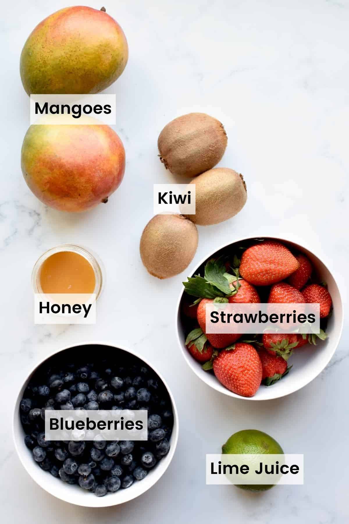 Labeled ingredients for mango berry fruit salad.