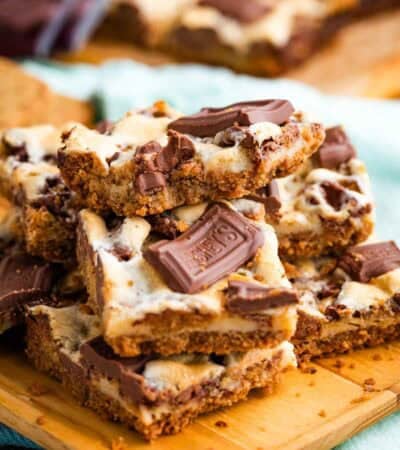 Close-up image of s'more bars stacked on a cutting board.