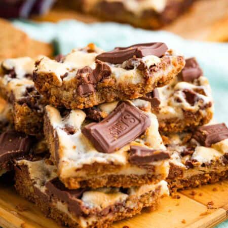 Close-up image of s'more bars stacked on a cutting board.
