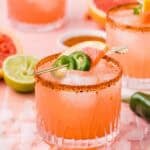 A grapefruit margarita garnished with jalapeno wheels and a slice of grapefruit.