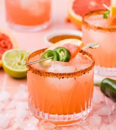 A grapefruit margarita garnished with jalapeno wheels and a slice of grapefruit.