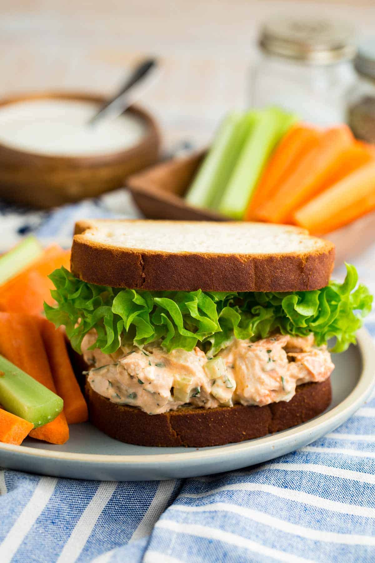 This flavor-packed Buffalo Chicken Salad is made with bold Greek yogurt dressing, tender chicken, crunchy veggies, and blue cheese. Yum! A buffalo chicken salad sandwich on a plate.