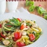 A salad with zoodles, tomatoes, and fresh mozzarella in a bowl with text overlay that says "Caprese Zucchini Noodles".