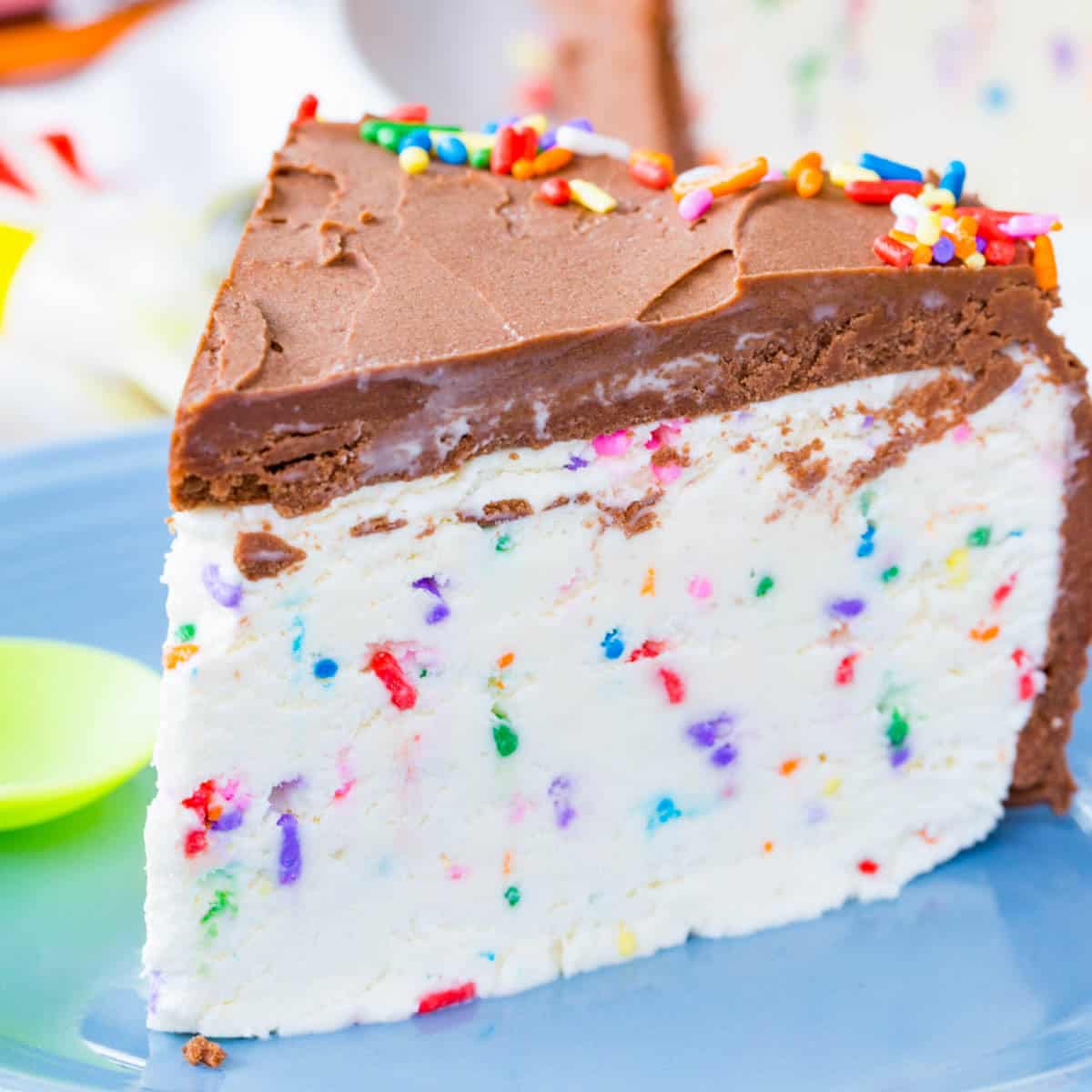 A slice of funfetti ice cream cake with chocolate frosting.