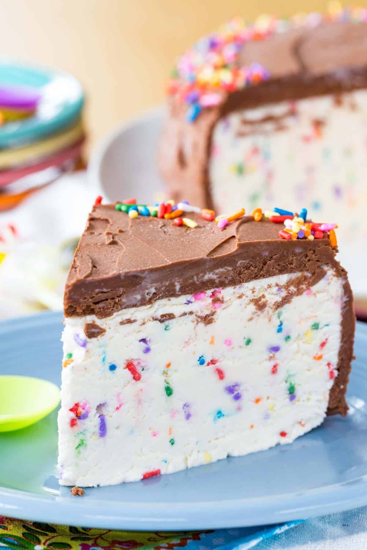A slice of ice cream cake with sprinkles inside and on top.