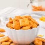 A bowl of cheese crackers with text overlay that says "Gluten Free Cheddar Crackers".