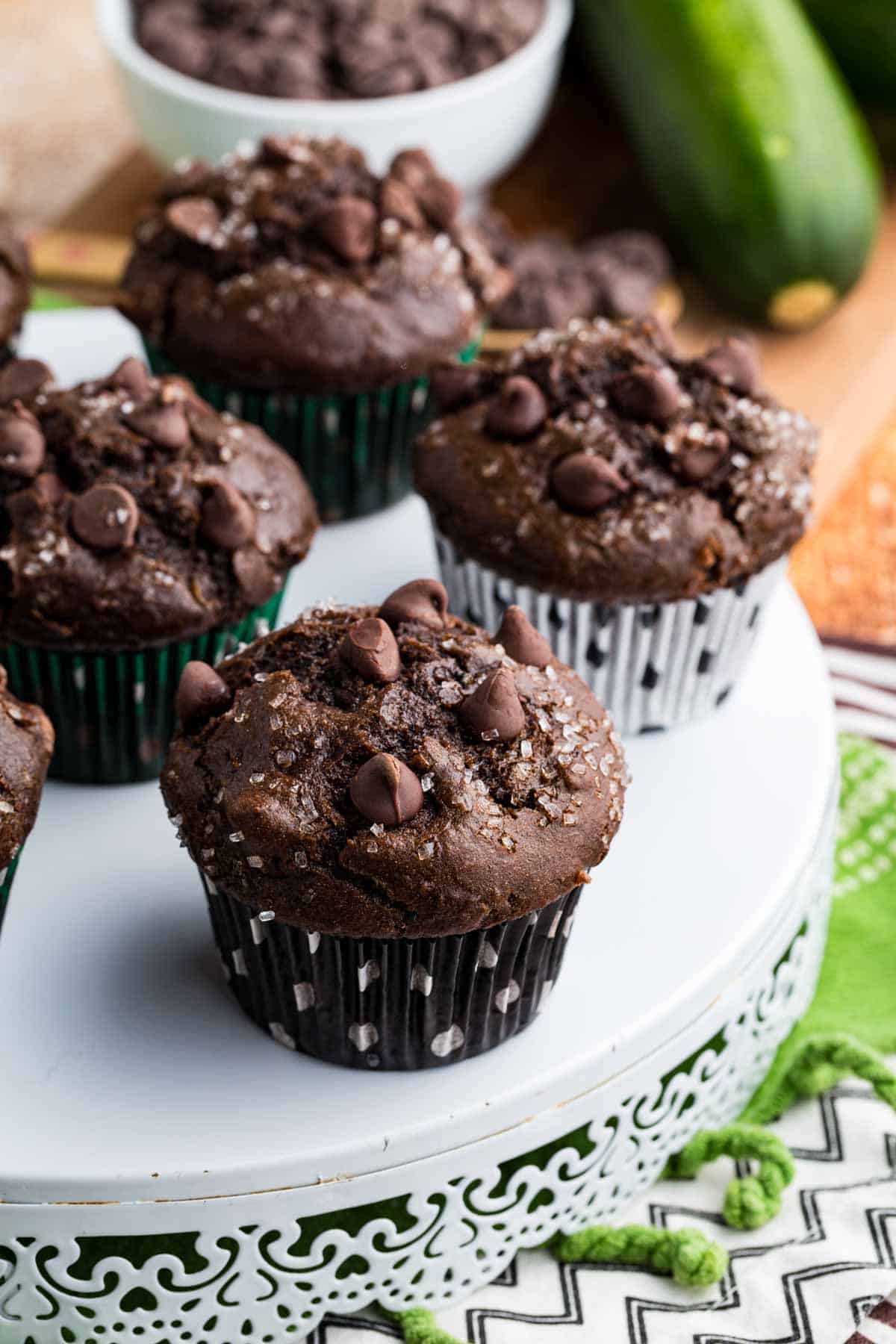 These gluten-free chocolate zucchini muffins are packed with melty chocolate chips and incredibly moist and tender, thanks to the zucchini. GF chocolate zucchini muffins in different colored wrappers.
