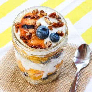 A grilled peach parfait with yogurt and blueberries.
