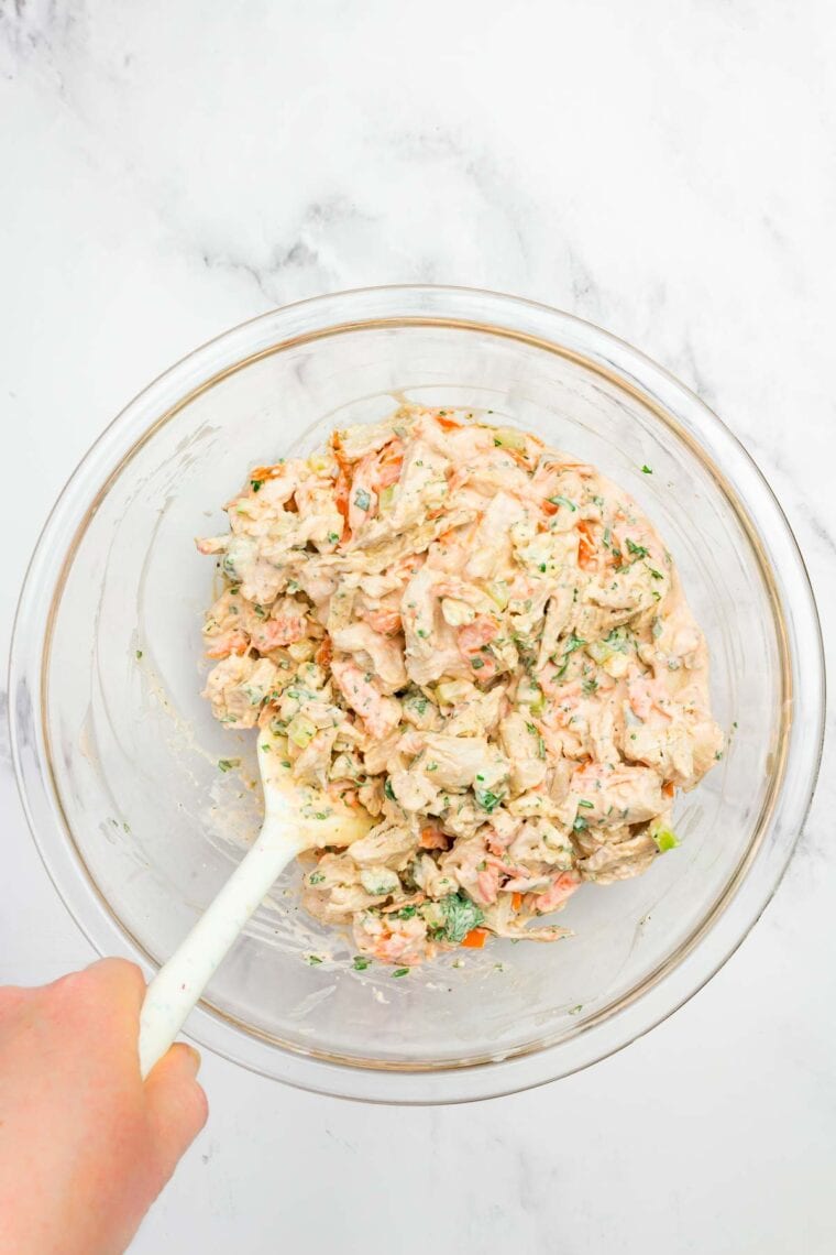 This flavor-packed Buffalo Chicken Salad is made with bold Greek yogurt dressing, tender chicken, crunchy veggies, and blue cheese. Yum! Tossing shredded chicken, veggies, parsley, and blue cheese with buffalo dressing.
