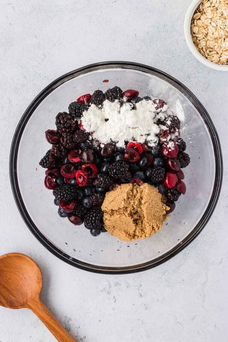 Berries, cornstarch, brown sugar, and lemon juice in a bowl.