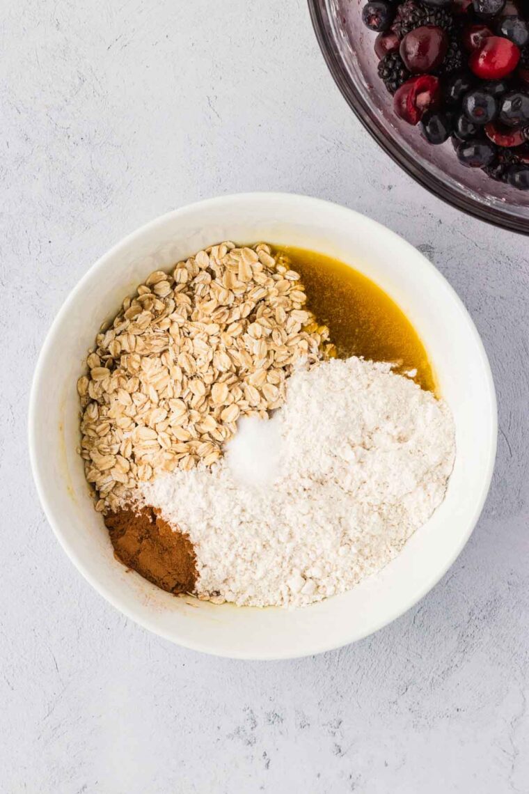 Adding flour, cinnamon, and oats to a mixture of melted butter and brown sugar.