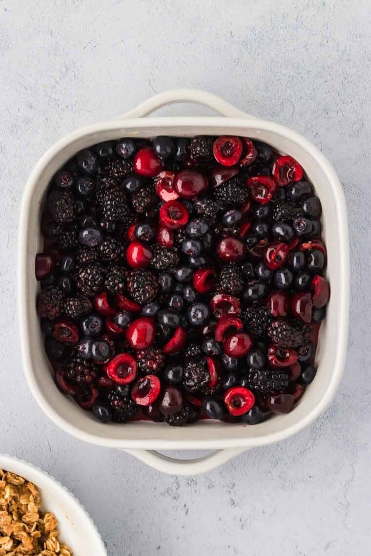 Adding berry filling to a casserole dish.