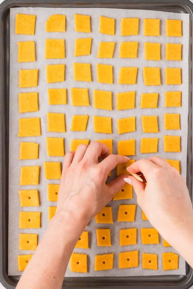 Poking a hole in GF cheesy crackers before baking.