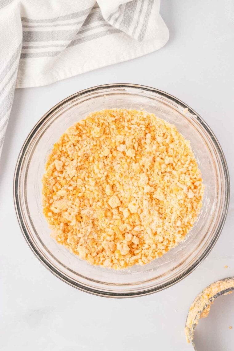 Cheddar cheese, butter, and water cut into a mixture of flour, cornstarch, garlic powder, and salt.