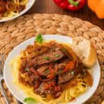 Steak pizzaiola served over pasta.