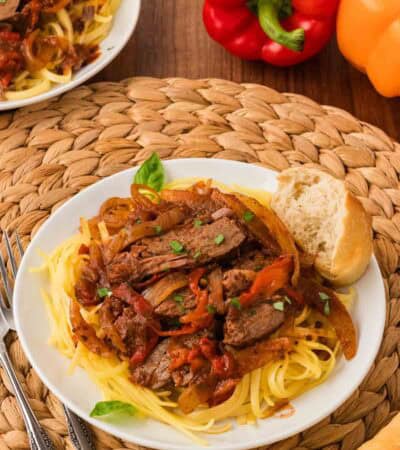 Steak pizzaiola served over pasta.
