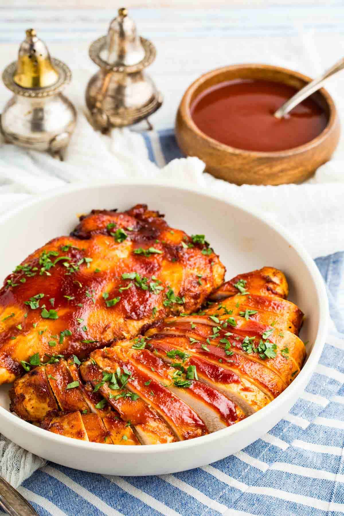 Two air fryer BBQ chicken breasts. One is sliced. One is not.