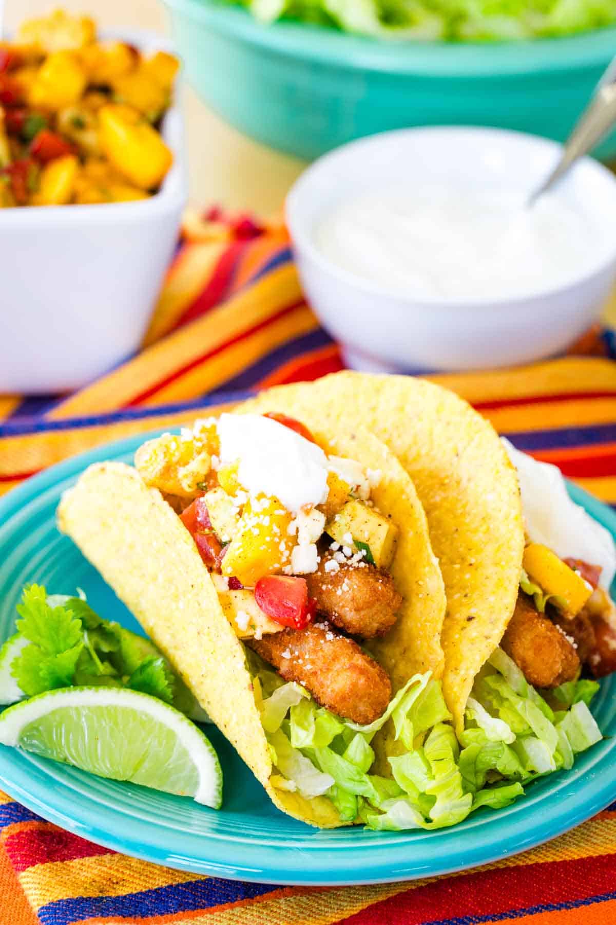 Two fish stick tacos on a blue plate.