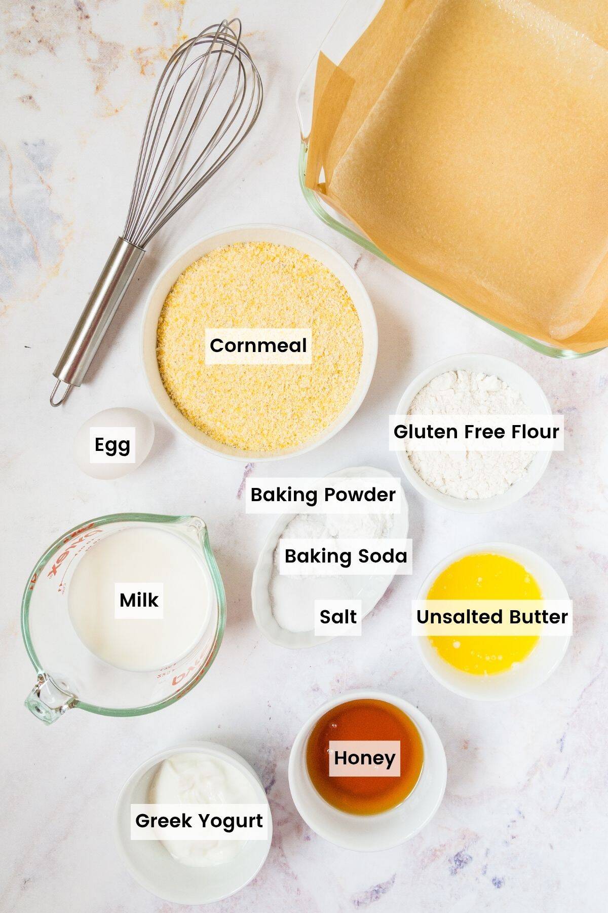Cornbread ingredients in small bowls, including cornmeal, flour, honey, yogurt, and milk with text labels.