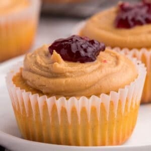 A cupcake topped with peanut butter frosting and jelly.