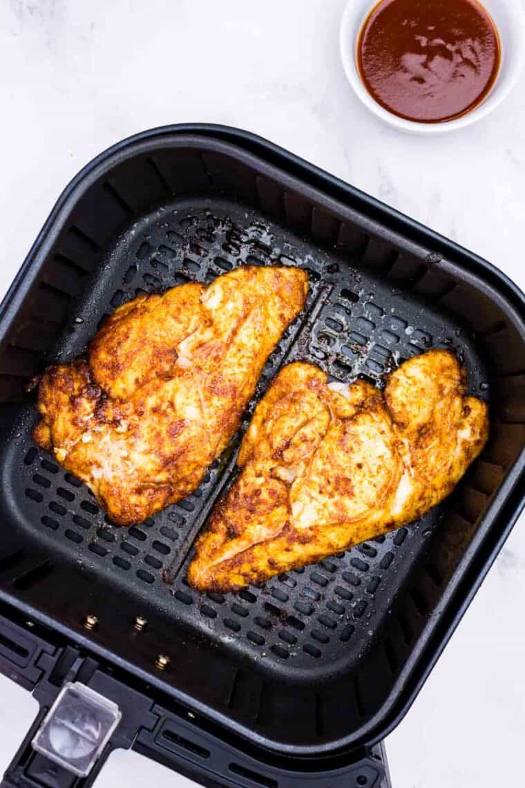 Seasoned chicken breasts in the air fryer (after flipping halfway through the cook time).