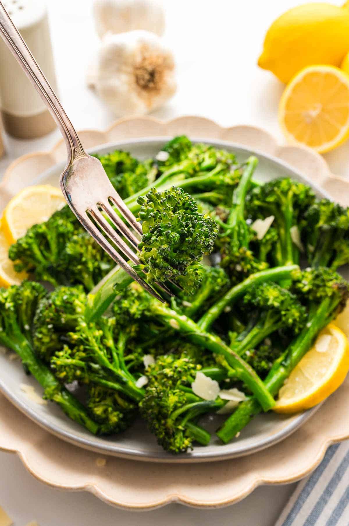 A fork taking a bite of saut&eacute;ed broccolini.