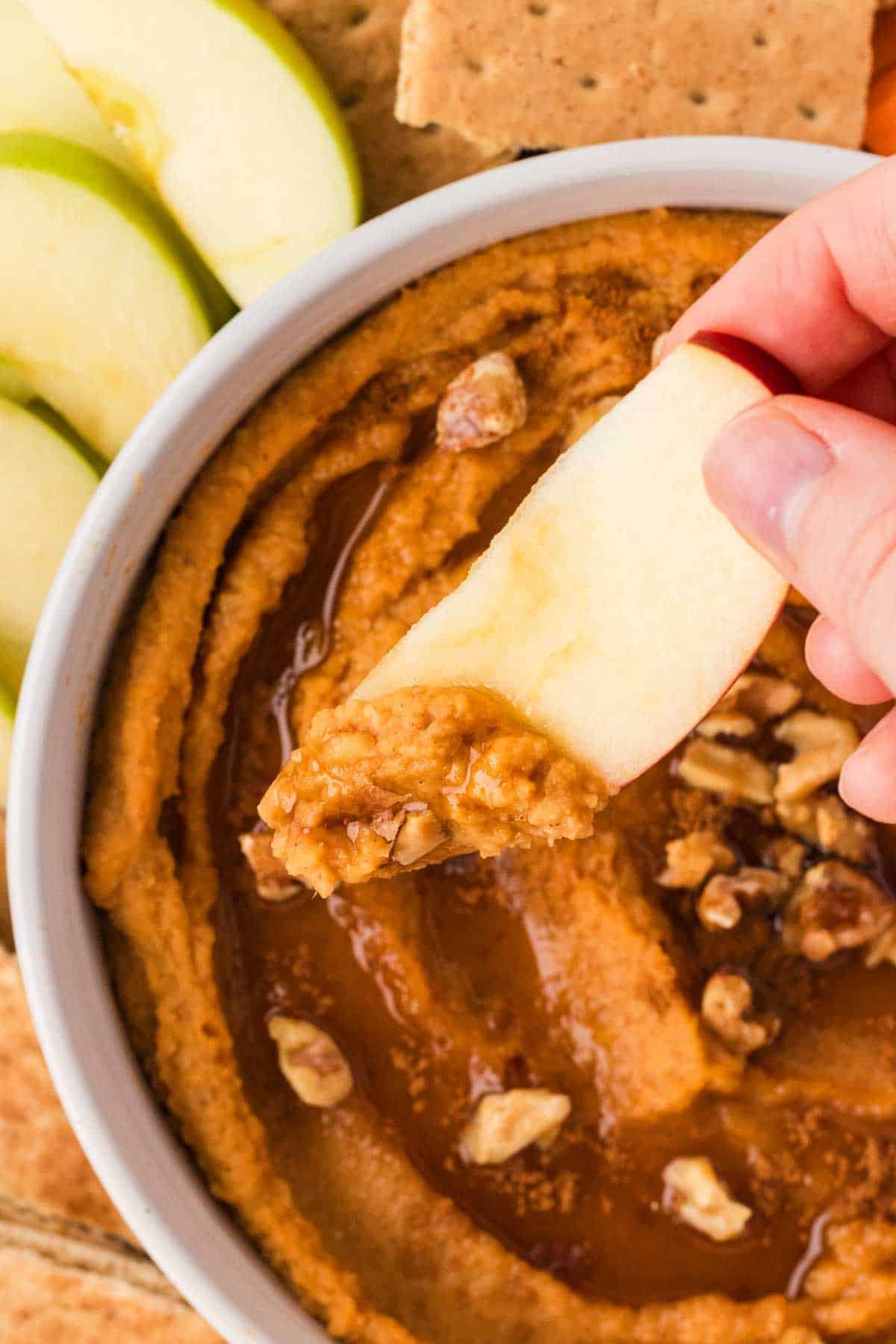 Dipping n apple into a bowl of sweet potato hummus.
