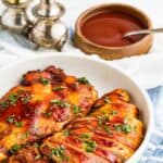 Two barbecue chicken breasts in a dish with one sliced with text overlay that says "Air Fryer BBQ Chicken Breasts".