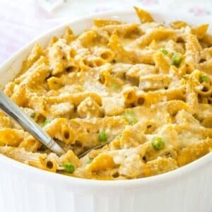 Penne pasta with pumpkin cream sauce in a casserole dish.