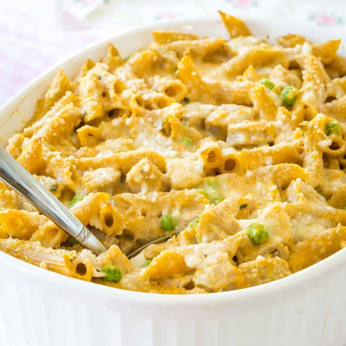 Penne pasta with pumpkin cream sauce in a casserole dish.