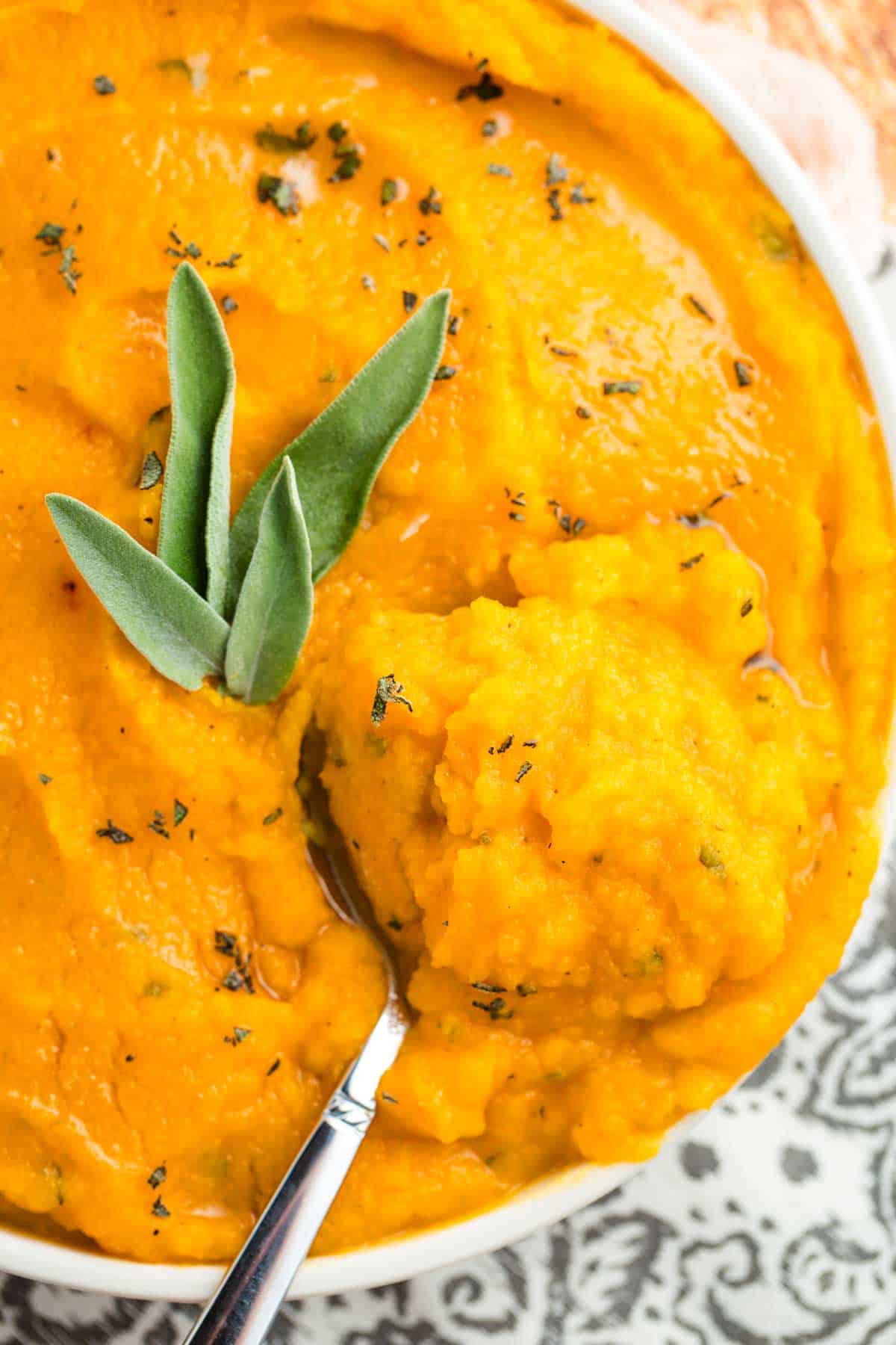 Overhead image of mashed butternut squash with a serving spoon in it.