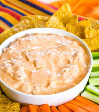 Bacon Buffalo blue cheese dip in a bowl surrounded by veggies and chips.