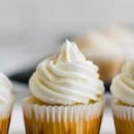 Cupcakes with piped vanilla frosting lined up with text overlay that says "Gluten Free Vanilla Cupcakes".