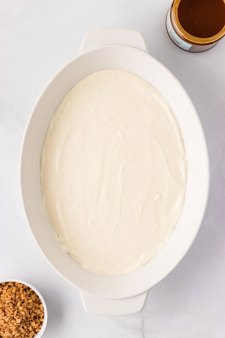 Greek yogurt dip spread into the bottom of a baking dish.
