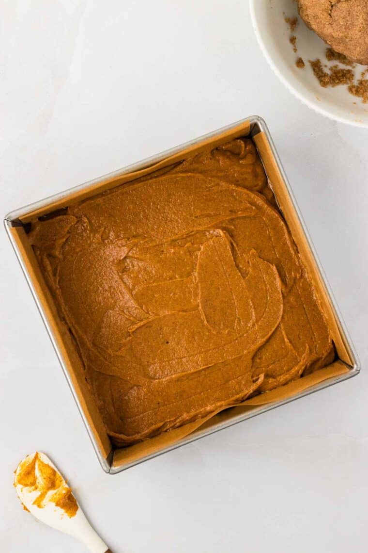 Pumpkin cake batter spread into a baking dish.