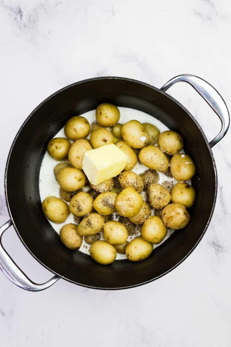 Adding butter, half-and-half, and seasonings to boiled creamer potatoes.