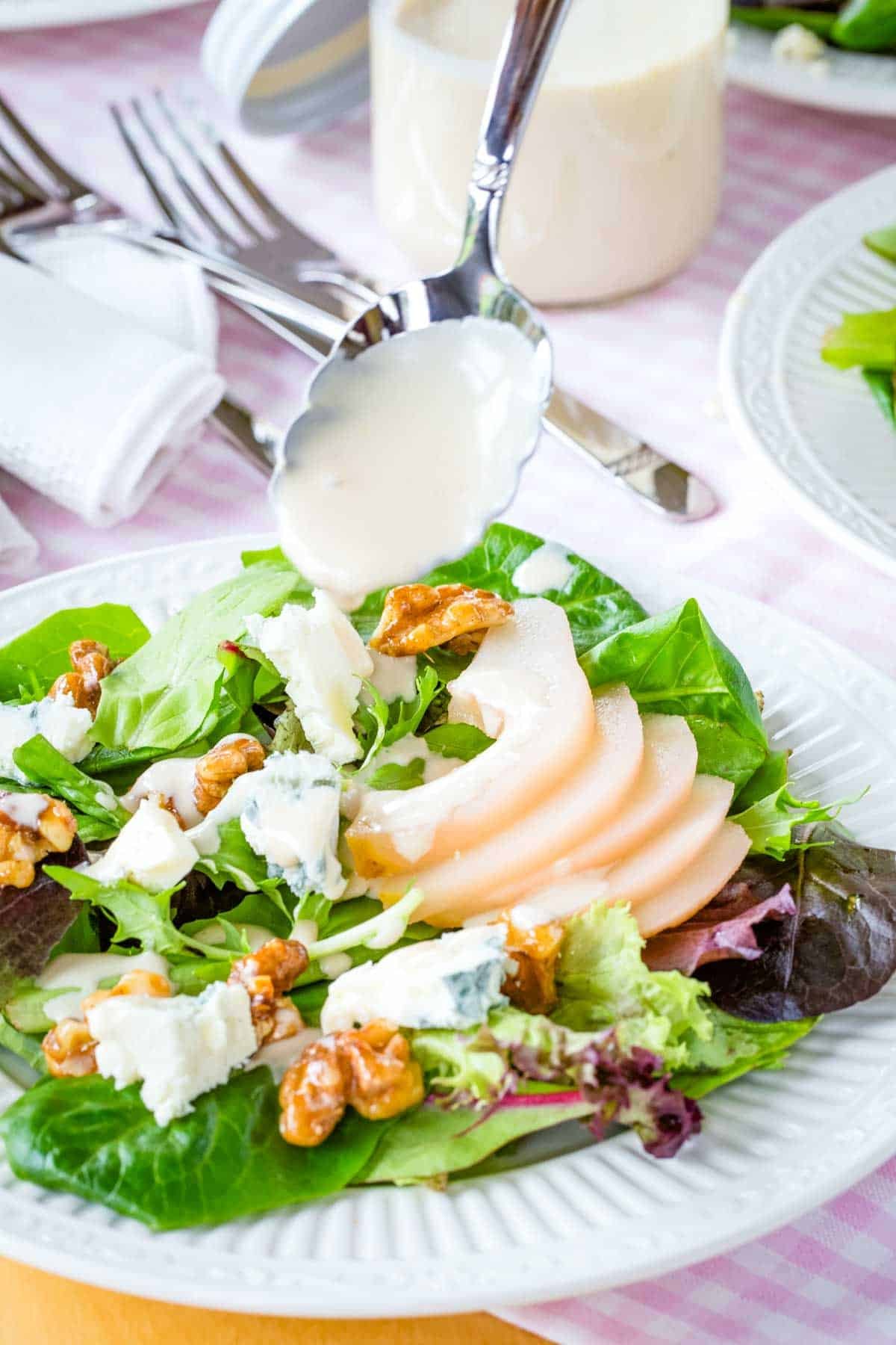 Drizzling sherry vinaigrette over poached pear salad.