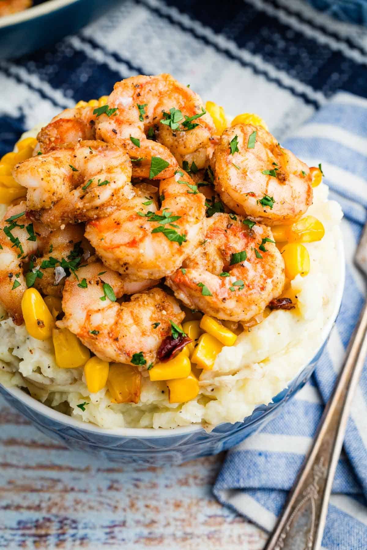 Close-up overhead image of shrimp and mashed potatoes in a bowl.