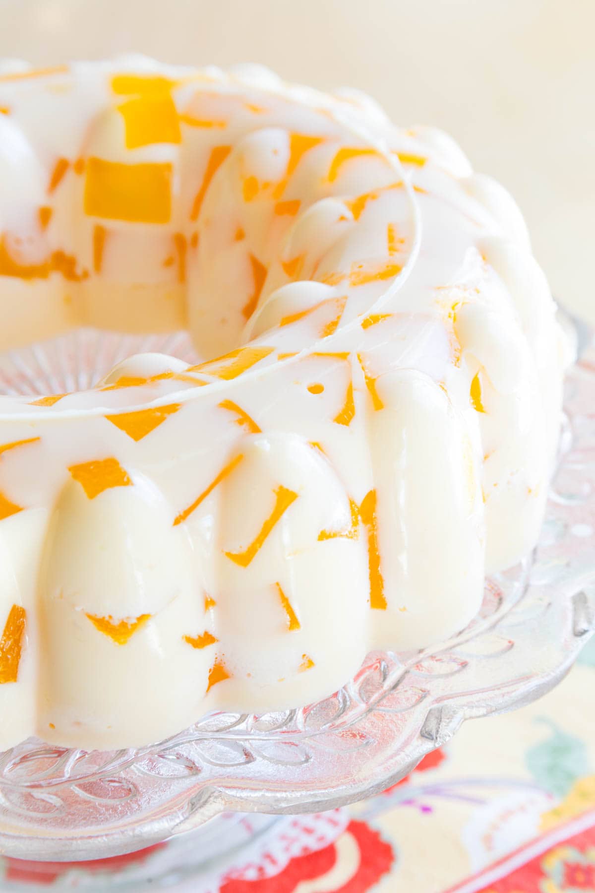 Close-up image of a creamsicle jello mold on a cake stand.