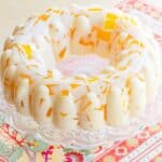 Overhead image of a creamsicle jello mold on a cake stand.