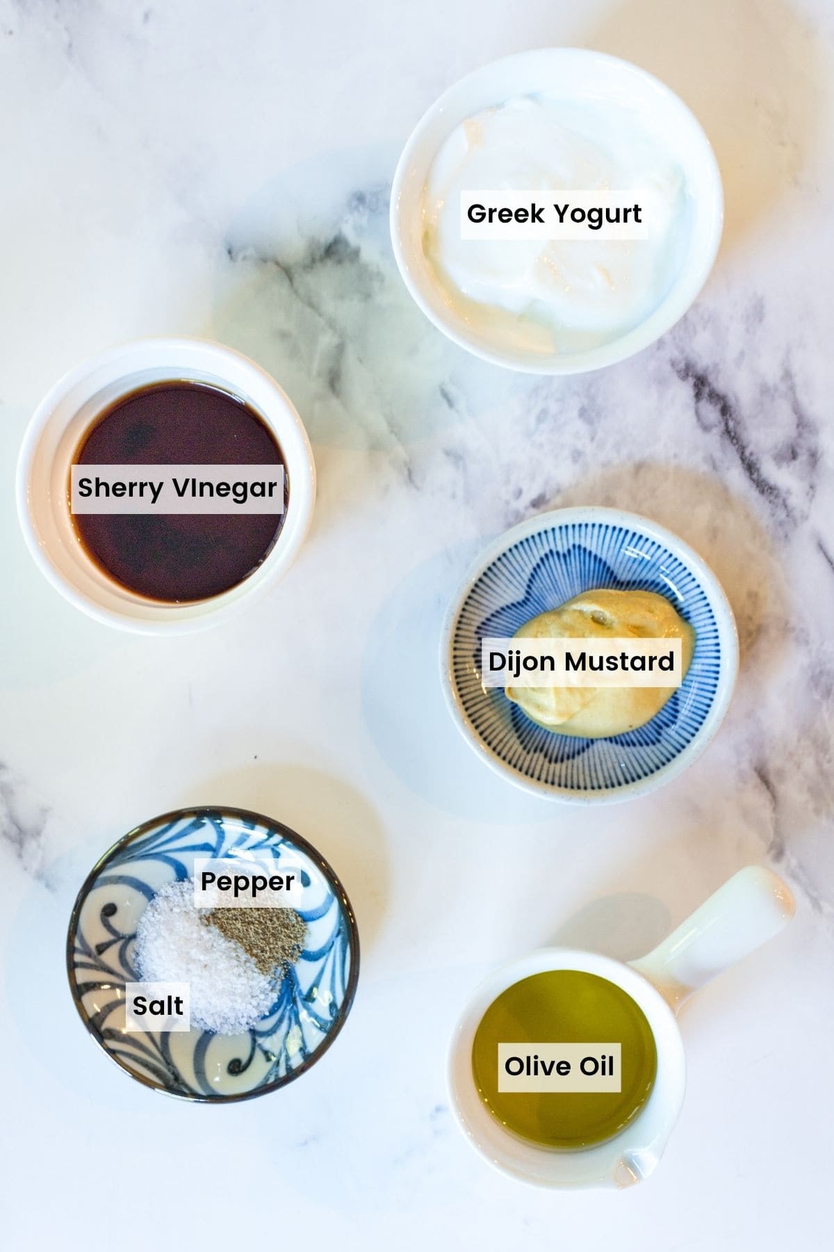 The ingredients to make sherry vinaigrette with text labels.